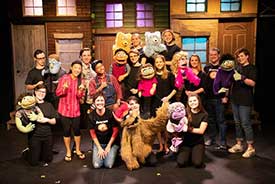A theater group on stage with muppets. Part of the CenterStage Theatre Company.